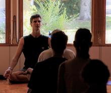 scott anderson sitting cross legged leading a meditation class